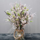Zarter handgebundener Trockenblumenstrauß mit Katzenschwänzchengras, Lavendel, Schleierkraut und Sonnenflügel.