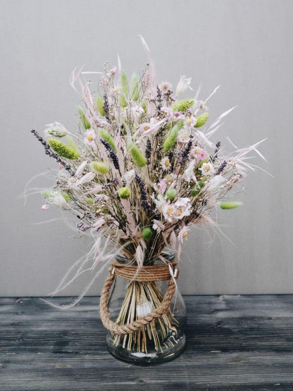 Zarter handgebundener Trockenblumenstrauß mit Katzenschwänzchengras, Lavendel, Schleierkraut und Sonnenflügel.