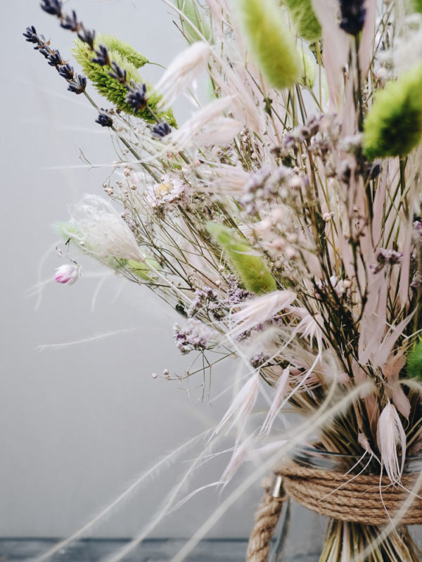 Zarter handgebundener Trockenblumenstrauß mit Katzenschwänzchengras, Lavendel, Schleierkraut und Sonnenflügel.