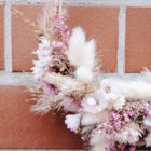 Roséfarbener, zartblumiger, kleiner Kranz aus Trockenblumen mit detailverliebter Blütenwahl.