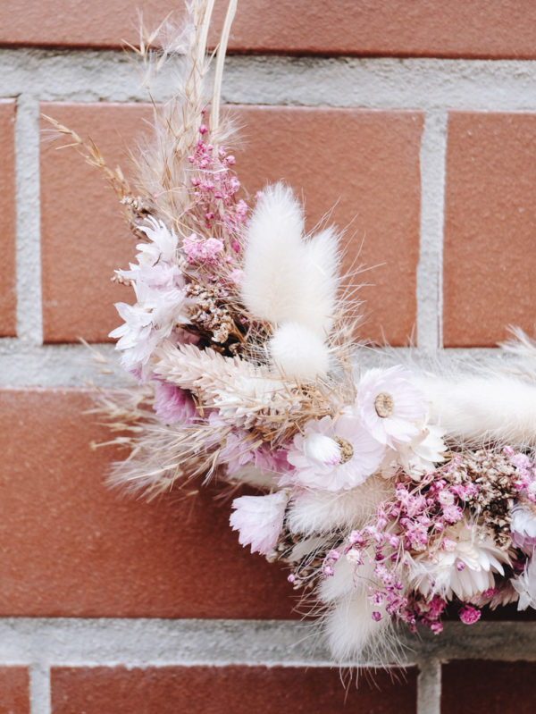 Roséfarbener, zartblumiger, kleiner Kranz aus Trockenblumen mit detailverliebter Blütenwahl.