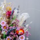 Zarter Brautstrauß aus Trockenblumen aus verschiedensten Blüten und Gräsern in fröhlichen Farben.