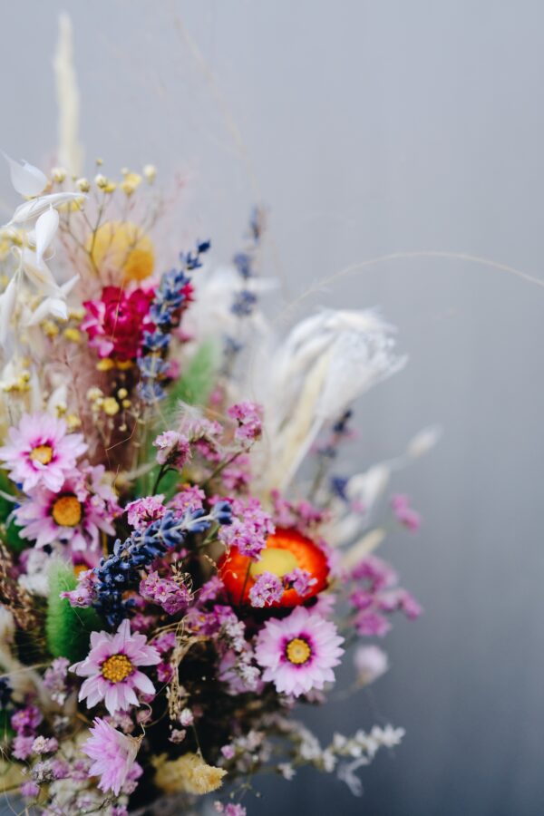Zarter Brautstrauß aus Trockenblumen aus verschiedensten Blüten und Gräsern in fröhlichen Farben.