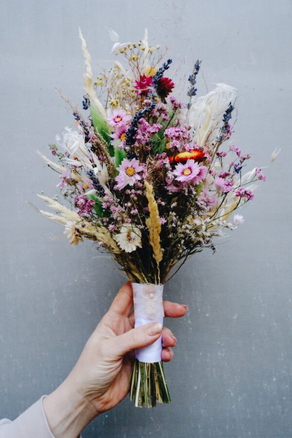 Zarter Brautstrauß aus Trockenblumen aus verschiedensten Blüten und Gräsern in fröhlichen Farben.