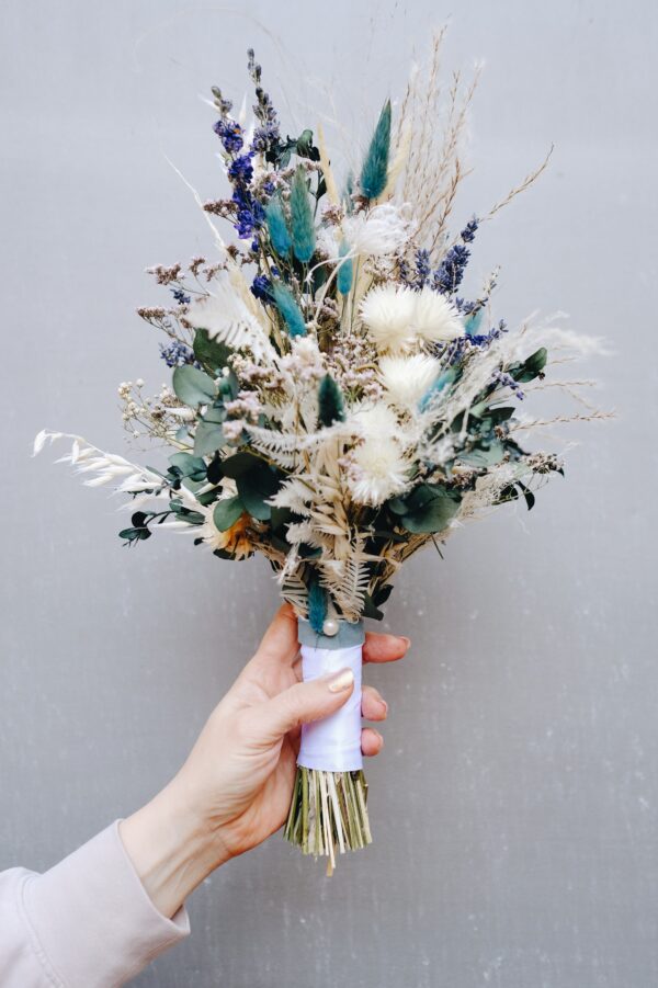 Zarter Brautstrauß aus Trockenblumen aus verschiedensten Blüten und Gräsern in fröhlichen Lavendelfarben.
