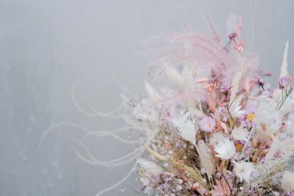Zarter Brautstrauß aus Trockenblumen aus verschiedensten Blüten und Gräsern in sanften Roséfarben.