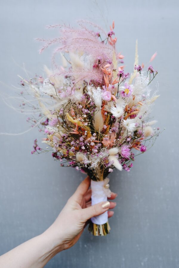 Zarter Brautstrauß aus Trockenblumen aus verschiedensten Blüten und Gräsern in sanften Roséfarben.