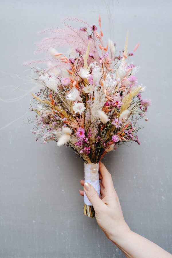 Zarter Brautstrauß aus Trockenblumen aus verschiedensten Blüten und Gräsern in sanften Roséfarben.