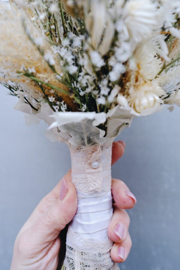 Zarter Brautstrauß aus Trockenblumen aus verschiedensten Blüten und Gräsern in hellen Farben.